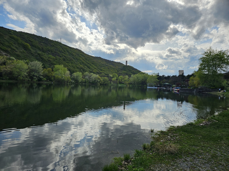 Turtle Lake with green hills and cloudy sky reflected on the water in Tbilisi, Georgia.