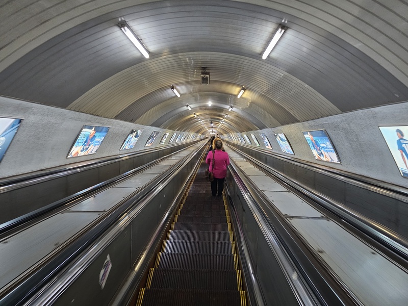 A view looking down a very long escalator in a Tbilisi metro station