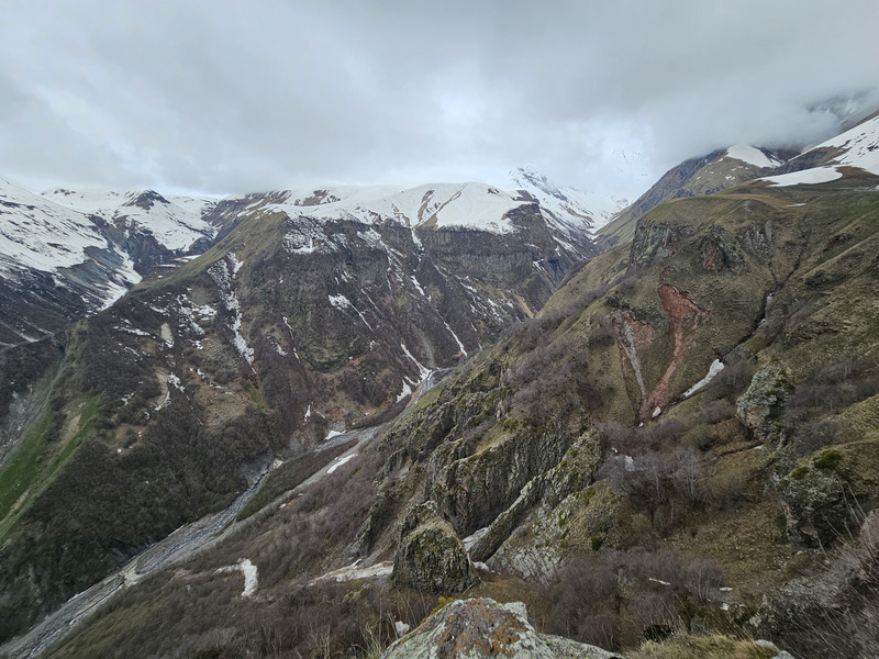 Snowy Caucasus mountains under low clouds near Kazbegi, Georgia.