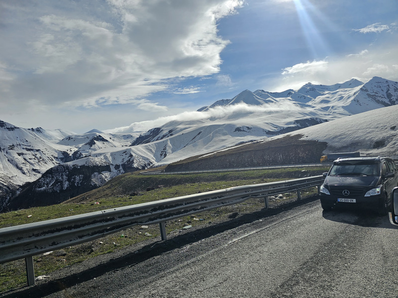 Snow-covered Caucasus mountains and a winding highway near Gudauri, Georgia.