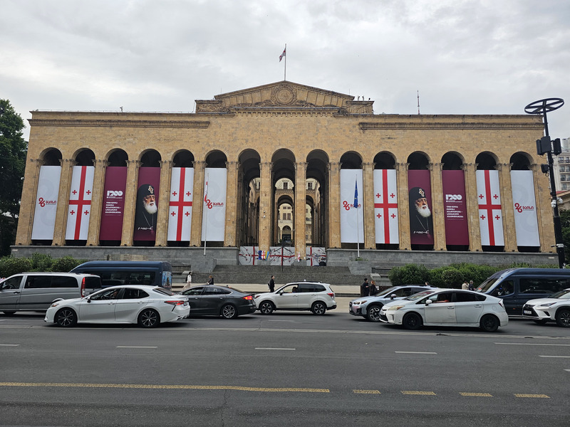 Georgian Parliament building on Rustaveli Avenue in Tbilisi, decorated with Georgian flags.