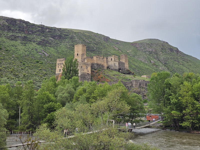 Khertvisi Fortress rising above a river and green hills in Georgia.